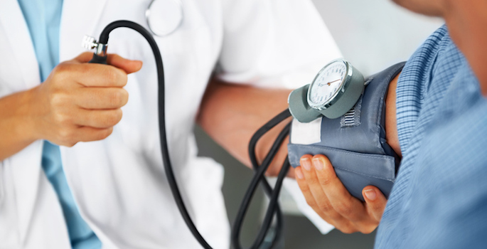 doctor checking patient's blood pressure